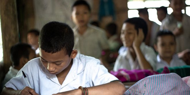 Close up of school boy writing in classroom teaching method